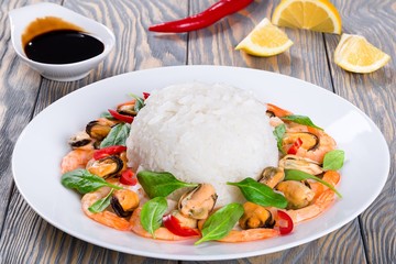 Rice and seafood: mussels, shrimps, baby spinach leaves, close-up