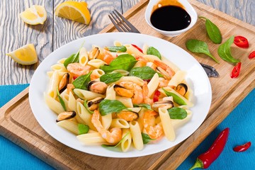 penne pasta salad with shrimps, mussels and baby spinach