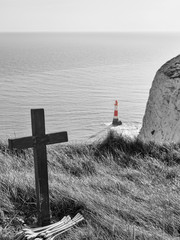 Kreuz mit rotem Leuchtturm im Hintergrund, East Sussex, England