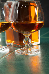 Glass of brandy on a green table top