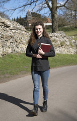 Young parish priest walking in her countryside parish