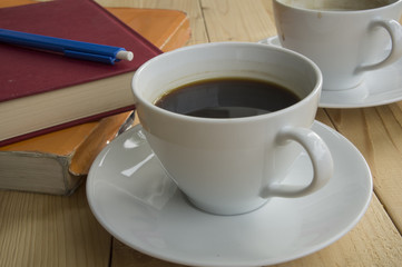 cup of coffee morning with red book blue pen