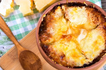 french onion gratin soup in a white pot, close-up