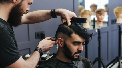 Male barber combing and shaving hair of a male client - 106431448