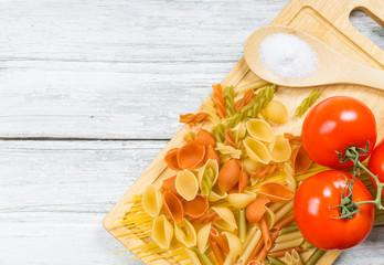Assorted dry pasta on wooden background