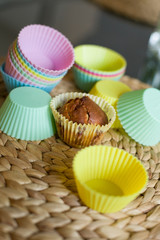 Colorful silicon molds for baking cupcakes and muffins on a straw table mat. Preparations for Easter celebration. Baking with family.