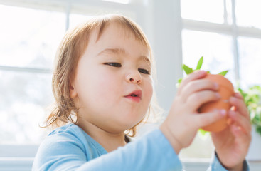  Happy toddler girl playing with potted plants