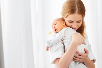 newborn baby in tender embrace of mother