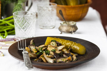 fried oyster mushrooms with garlic on a dark plate