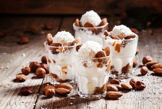 Ice cream with peanut sauce, hazelnuts and almonds in glasses, s