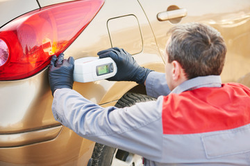 colourist man selecting color of car with paint matching scanner 