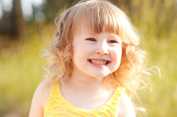 Smiling baby girl 3-4 year old walking in park outdoors. Looking down. Childhood. Playful.