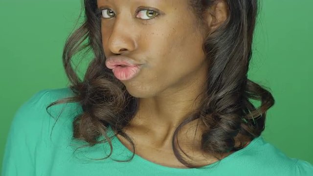 Beautiful African American Woman Making Silly Faces And A Fish Face, On A Green Screen Studio Background