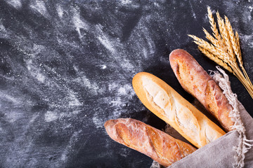 bread with wheat ears on dark board