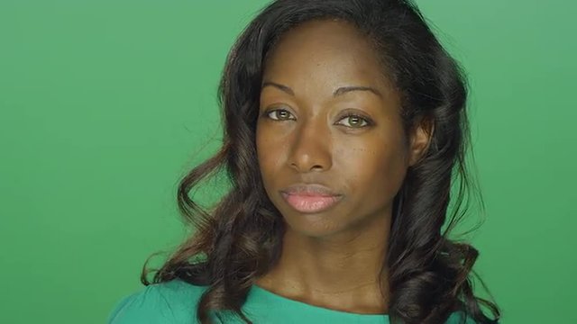 Beautiful African American woman looking tough and staring, on a green screen studio background