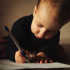Little beautiful girl writing in her book
