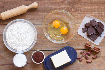 Ingredients for making chocolate chip cookies on a wooden background