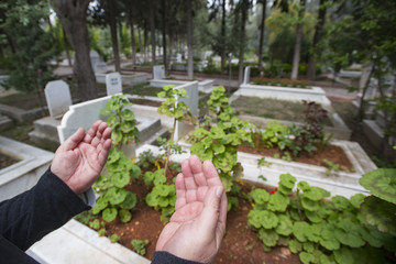 Muslim man hands praying near the grave