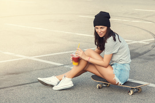 Sexy girl sitting on the skateboard
