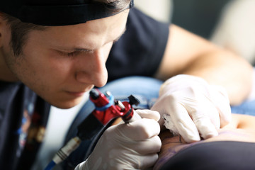 Tattooist makes tattoo, close up