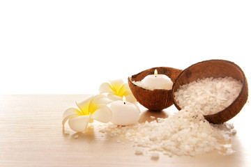 Spa concept of plumeria, coconut and candles with sea salt, isolated on white