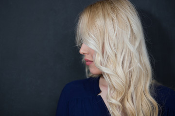 Blond woman in shirt against chalkboard, copyspace