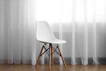 Chair in the room near the window with curtains