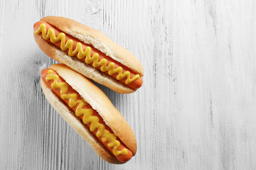 Two hot dogs on wooden background
