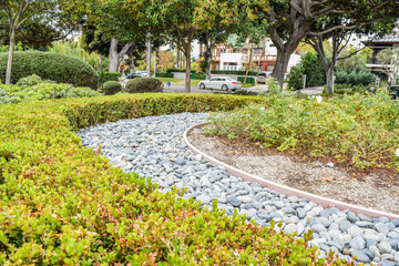 Beverly Gardens Park Nicely trimmed bushes, flowers and stones in front of the house, front yard. Landscape design.