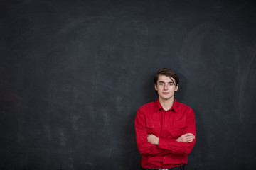 Businessman standing in a front of black background in red shirt