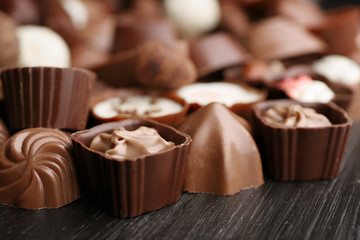 Delicious chocolate candies on wooden background, close up