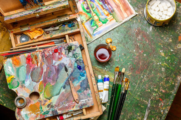 Colorful workplace of the artist with brushes and oil paints