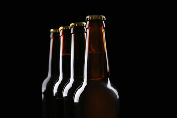 Four bottles of beer on black background