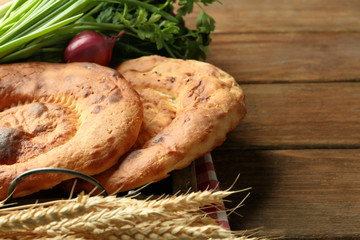 Fresh fried bread with onion on wooden table closeup