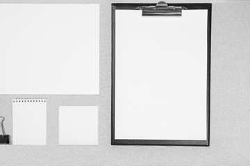 Office set with white sheets of paper, notebook and stationery on grey background