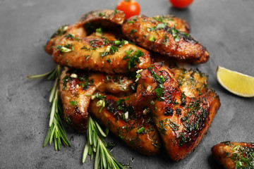 Baked chicken wings with spices on grey background