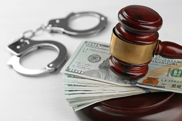 Law gavel with dollars and handcuffs isolated on white