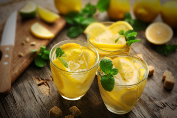 Composition lemonades with lemons and mint on wooden table background