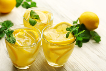 Composition of lemonades with lemons and mint on white wooden table background, closeup