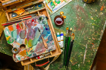 Colorful workplace of the artist with brushes and oil paints
