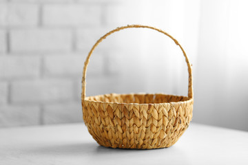 Fototapeta na wymiar Wicker basket with handle on wooden table, closeup