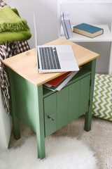 Nightstand with laptop in interior of living room