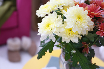 Beautiful flowers on table in interior of living room, closeup