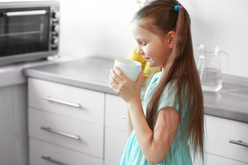 Girl drinking water in the kitchen