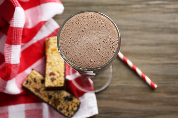 Glass of chocolate milkshake and cookies on wooden background