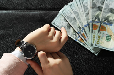 Businesswoman with watch and brief case full of money money