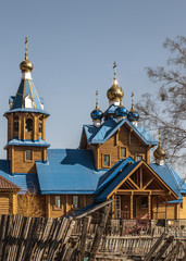 Fototapeta premium wooden Russian Orthodox Church with domes on a background of blue sky
