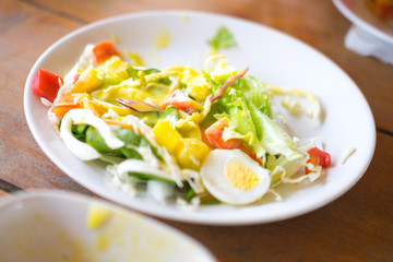 Eating vegetable saalad with boiled eggs