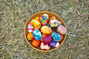 Colorful easter eggs in a bowl on an old grass
