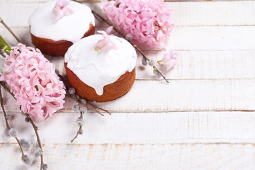 Easter cake, pink hyacinth, willow branches on white wooden back